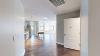 Located in the heart of downtown Rochester, NY, this thoughtfully designed three-bedroom, three-bathroom unit on East Main Street offers a refined urban living experience across a single, well-appointed floor. The open-concept kitchen and living area serves as the central hub of the home, featuring hardwood flooring, track lighting, and a sleek, modern kitchen outfitted with stainless steel appliances, a gas range, subway tile backsplash, and contemporary cabinetry with ample storage. Natural light flows generously throughout, with multiple windows framing views of the Rochester cityscape. The spacious primary bedroom is carpeted for comfort and includes its own en-suite bathroom with a modern floating vanity, white quartz countertop, and large framed mirror. The additional bedrooms are well-proportioned, with hardwood or carpeted floors and windows offering urban views. The bathrooms maintain a clean, minimalist aesthetic with neutral tile and quality fixtures. A dedicated in-unit laundry room houses a full-sized washer and dryer. Two closets provide practical storage solutions, complemented by wire shelving systems. The hallway connects all spaces cohesively, and the overall design palette of warm neutrals and modern finishes gives the unit a polished, contemporary feel throughout.