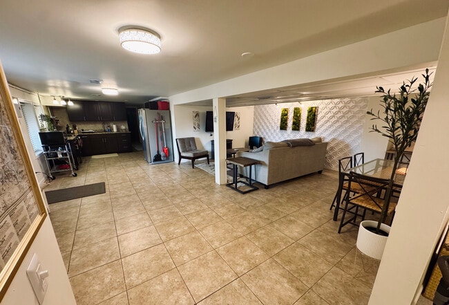 Basement apartment view including living room, entrance, dining table and kitchen areas. - 11116 Kensington Ave
