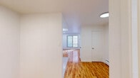 Located at 2415-2425 Avenue Madison in the Notre-Dame-de-Grâce neighbourhood of Montréal, this unit offers a thoughtfully organized single-floor layout that makes efficient use of its space. Warm-toned hardwood flooring runs continuously throughout the main living areas, lending a cohesive and inviting feel to the interior.

The open living and dining area is bright and airy, illuminated by recessed ceiling lights and a sliding glass door that opens onto a small wrought-iron balcony, allowing natural light to filter in while providing a pleasant outdoor view. Clean white walls complement the light wood floors and contribute to an overall sense of openness.

The kitchen is positioned at the rear of the main living space and features warm wood cabinetry, a white electric stove, a refrigerator, and a single basin sink with a tiled backsplash — providing all essential amenities in a compact and practical arrangement.

A hallway connects the main living area to the rest of the unit, leading to the bathroom. The bathroom is finished with classic white subway tiles surrounding a full-sized soaking tub with an overhead shower, paired with a toilet, creating a clean and functional space.

The unit's straightforward layout, consistent finishes, and access to a balcony make it a practical and comfortable space in a well-established Montréal residential area.