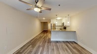 Located in Marietta, GA, this single-floor unit offers a clean, modern aesthetic with an open-concept design that seamlessly connects the kitchen, dining, and living areas. Wide-plank wood-look flooring runs throughout the entire space, lending warmth and visual continuity from room to room.

The kitchen is a standout feature, outfitted with crisp white shaker-style cabinetry, gray quartz countertops, a subway tile backsplash, and a full suite of stainless steel appliances including a refrigerator, range, microwave, and dishwasher. Stylish pendant lighting over the kitchen island adds a contemporary touch. The open layout connects directly to the spacious living area, which is equipped with a ceiling fan and benefits from natural light courtesy of French doors leading to the exterior.

The bedrooms are generously proportioned, each with ceiling fans and the same wood-look flooring, creating a cohesive and comfortable atmosphere. The bathroom features a soaking tub with a tiled surround in a clean marble-look finish, complemented by brushed nickel hardware and wood-look flooring that ties in with the rest of the unit.

Neutral wall tones throughout provide a versatile backdrop, making the space move-in ready and easy to personalize. The overall ambiance is fresh, bright, and well-appointed.