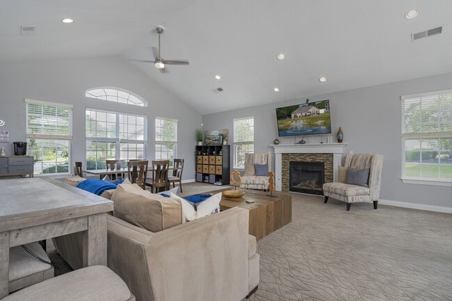 Gather with neighbors in a spacious community lounge, featuring a cozy fireplace and comfortable areas to relax or socialize. - Wheaton Village Apartments