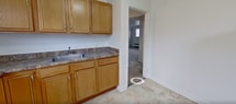 This 550 square foot apartment in Albany, NY offers a thoughtful layout with 2 bedrooms and 1 bathroom. The primary bedroom, measuring 240 square feet, provides ample space and features carpeted flooring and dual windows for natural light. The second bedroom, while smaller, maintains a cozy atmosphere with similar finishes.

The recently updated bathroom showcases a modern aesthetic with marble-like tiling, a combination tub/shower, and a sleek vanity. The kitchen, though compact, is efficiently designed with wooden cabinetry, granite countertops, and essential appliances including a gas stove.

Throughout the apartment, neutral tones dominate, creating a bright and airy feel. Carpeting in the bedrooms and living areas adds warmth, while the kitchen and bathroom feature durable tile flooring. Baseboard heating units ensure comfort during colder months.

The layout includes two hallways for easy navigation between rooms. Despite its modest size, the apartment maximizes space usage, offering a comfortable living environment. The single-floor design enhances accessibility, making this unit suitable for various lifestyles.