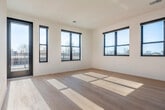 Located at 826 Williamson St in Madison's vibrant Williamson Street corridor, this modern 3-bedroom, 4-bathroom unit offers a thoughtfully designed single-floor layout with clean, contemporary finishes throughout. Light hardwood flooring flows seamlessly across the entire space, complementing the crisp white walls and an abundance of natural light.

The kitchen is well-appointed with stainless steel appliances—including a range, over-the-range microwave, and dishwasher—paired with two-tone cabinetry featuring warm wood lower cabinets and white upper cabinets, accented by a subtle tile backsplash and sleek white countertops. The kitchen opens directly to the living area, creating an inviting, connected space.

The generously sized primary bedroom offers ample room and direct access to a well-finished bathroom featuring warm wood vanity cabinetry, a white countertop, and a bathtub/shower combination. Additional bedrooms are bright and well-proportioned, each with ceiling fans. A dedicated walk-in closet with wire shelving provides practical storage.

A hallway off the main corridor houses a convenient in-unit washer/dryer. The four bathrooms are clean and modern, consistent in their finishes throughout. A standout feature is the large outdoor deck with sleek metal railings, offering open views of the surrounding Madison skyline and treetops under wide-open skies.