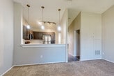 Located at 4937 Waterway Court in Orlando, FL, this single-story, one-bedroom, one-bathroom residence offers a well-designed layout that maximizes its cozy footprint. The open-concept living, dining, and kitchen area serves as the heart of the home, highlighted by soaring vaulted ceilings and a ceiling fan that enhance the sense of airiness. A sliding glass door floods the living space with natural light and provides outdoor access, complemented by an additional window with blinds.

The kitchen is a standout feature, equipped with stainless steel appliances including a refrigerator, range, microwave, and dishwasher. Rich gray shaker-style cabinetry pairs with a white subway tile backsplash and light countertops, while wood-look flooring grounds the space. A raised breakfast bar connects the kitchen to the living area, ideal for casual dining.

The bedroom is generously sized with vaulted ceilings, soft carpet flooring, a ceiling fan, a natural light window, and a louvered bi-fold closet. The bathroom features wood-look tile flooring and tiled tub surround walls, offering a clean and functional design. Neutral tones and carpet in the living and sleeping areas create a warm, cohesive ambiance throughout the home.