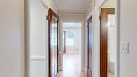 Located in Seattle's desirable University District at 4337 15th Ave NE, this 2-bedroom, 1-bathroom residence offers a thoughtfully designed single-floor layout that maximizes every square foot. Warm hardwood floors run throughout the home, tying together each room with a cohesive, classic feel.

The spacious primary bedroom is one of the home's standout features, benefiting from multiple windows on two walls and a ceiling fan with light fixture, allowing abundant natural light and excellent ventilation. The second bedroom mirrors this brightness with its own set of windows and ceiling fan. Both rooms offer a calm, airy ambiance.

The hallway connecting the rooms is lined with rich, dark wood-framed doors — one featuring elegant glass pane detailing — adding architectural character to the space. A dedicated closet provides convenient storage.

The kitchen is bright and efficient, equipped with white cabinetry, granite-style countertops, a skylight, and white appliances including a refrigerator and range. A secondary kitchen or butler's pantry area extends the storage and prep space further, lined with white cabinetry and granite countertops on both sides.

The bathroom retains classic charm with traditional white hex tile flooring accented by a blue border detail and a wood-framed mirror door. Clean, neutral tones throughout the home create a welcoming and timeless atmosphere.