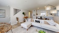 This two-story residence offers a thoughtfully designed layout with a blend of modern finishes and functional living spaces. The main level features an open-concept living and dining area with light hardwood-style flooring, recessed lighting, and a staircase connecting to the upper level. The living room provides ample space for seating and flows seamlessly toward the dining area, which benefits from natural light through nearby windows.

The kitchen is outfitted with dark espresso cabinetry, light quartz countertops, and a full suite of stainless steel appliances, including a range, over-the-range microwave, dishwasher, and refrigerator. A dedicated laundry area with a full-size washer and dryer is conveniently located on the main level.

The upper level houses the bedrooms, including a primary bedroom with plush carpeting, a ceiling fan, and generous space for furnishings. Additional bedrooms also feature carpet flooring and windows that bring in natural light and exterior views. The bathrooms are clean and functional, each featuring a tub-shower combination with tiled surrounds and vanities with ample storage. The overall ambiance throughout is neutral, bright, and move-in ready.