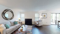 This single-floor residence at 175 N Mount Tabor Rd in Lexington, Kentucky offers a well-organized and comfortable layout across several distinct living areas. The living room serves as the heart of the home, featuring a sleek black fireplace flanked by windows that allow natural light to fill the space. Rich hardwood-style flooring runs throughout the main living areas, adding warmth and continuity to the design. A dedicated dining area adjacent to the living room is highlighted by a sliding glass door that opens to an outdoor deck, providing a seamless connection to the exterior and views of the surrounding greenery. The galley-style kitchen is efficiently designed with dark cabinetry, granite-look countertops, a double-basin stainless steel sink, and black appliances, centered around a window that brings in additional natural light. The bedroom offers a quieter retreat with plush carpeting and a window, while a flexible secondary room with carpeting and large windows can serve as a home office or additional living space. The bathroom is clean and functional, equipped with a vanity featuring dark cabinetry and a glass-enclosed shower. Throughout the space, neutral wall tones and consistent finishes create a cohesive, inviting atmosphere.