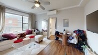 Located at 817 W Lakeside Pl in Chicago's vibrant Uptown neighborhood, this efficiently designed one-bedroom, two-bathroom unit makes excellent use of its compact footprint. The open living area features rich hardwood floors, crown molding, a ceiling fan, and a wall-mounted split HVAC system for year-round comfort. Natural light streams in through multiple windows dressed with curtains, creating a bright and welcoming atmosphere. The living space accommodates both a seating area and a dining nook, offering functional versatility.

The kitchen is outfitted with white shaker-style cabinetry, a grey subway tile backsplash, dark countertops, and a full suite of stainless steel appliances including a gas range, microwave, and refrigerator — well-equipped for everyday cooking. The bedroom is an intimate, cozy space highlighted by a window with sheer curtains that allows soft natural light, complemented by a round wall mirror that adds depth to the room. Both bathrooms are clean and functional, with one featuring a classic subway-tiled bathtub and a window for ventilation. Throughout the unit, neutral tones and consistent hardwood flooring tie the spaces together into a cohesive, practical urban home.