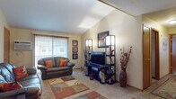Located at 2101 Freeman Pkwy in Beloit, Wisconsin, this single-floor residence offers a well-organized layout with distinct living spaces designed for comfortable everyday living. The living room is a standout feature, boasting vaulted ceilings that lend a sense of openness and volume to the space. Carpeted flooring, a large window with vertical blinds allowing natural light, and ample room for seating make this area both functional and welcoming. A second seating area connects seamlessly, providing additional lounge space with easy access to the entryway. The kitchen is efficiently laid out with warm wood cabinetry, granite-style countertops, tile flooring, and full appliances including a refrigerator, stove, dishwasher, and microwave. The primary bedroom is a calm retreat with carpeted floors, natural light from a window with blinds, and generous closet access. A second bedroom offers flexible use as a guest room or office space, featuring carpeted floors and a window. The full bathroom includes a tub-shower combination, a single-sink vanity with wood cabinetry, and tile flooring. Throughout, the warm neutral color palette and consistent finishes create a cohesive and comfortable living environment.