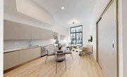 Located at 640 NW 7th Ave in Fort Lauderdale, FL, this modern 1-bedroom, 1-bathroom residence offers a thoughtfully designed open-concept layout with soaring ceilings that amplify the sense of space throughout. Light wood-tone flooring flows seamlessly from the combined kitchen and living area through the hallway and into the bedroom, creating a cohesive and airy aesthetic.

The kitchen is outfitted with stainless steel appliances — including a refrigerator, range, microwave, and dishwasher — complemented by flat-front taupe cabinetry and a clean-lined countertop. A dining area with a round table sits adjacent to the kitchen, making the space ideal for both everyday living and entertaining.

The living room is anchored by dramatic floor-to-ceiling windows with sliding glass door access to a balcony overlooking a lush, landscaped courtyard with palm trees. The bedroom mirrors this feature with its own expansive window, flooding the room with natural light and offering serene outdoor views. Two closets provide ample storage.

The bathroom features a floating vanity with an undermount sink, a soaking tub, and clean white tile finishes. Additional conveniences include in-unit laundry and a utility room, rounding out this well-appointed Fort Lauderdale residence.