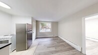 Located at 1516 Bathurst Street in Toronto's vibrant Midtown neighbourhood, this compact one-bedroom, one-bathroom unit offers an efficient and well-organized layout across a single floor. Light-toned laminate wood flooring flows throughout the main living areas and bedroom, lending the space a clean, contemporary feel.

The kitchen is equipped with a stainless steel refrigerator, a white electric stove, and a countertop with an undermount sink. Tile flooring in the kitchen provides a practical transition from the main living area. A window in the kitchen/dining area allows natural light to filter in, offering a pleasant view of the surrounding brick exterior of the building.

The bedroom is a cozy, well-proportioned room featuring the same light laminate flooring, neutral warm-beige walls, and a window fitted with a wall-mounted air conditioning unit, ensuring year-round comfort. Baseboard heating is present throughout the unit, providing consistent warmth during colder months.

The bathroom is outfitted with a full-sized soaker bathtub and shower combination, surrounded by classic beige square wall tiles and chrome fixtures, complemented by a clean white vanity.

Overall, the unit presents a tidy, functional living space with a neutral palette and practical finishes, ideally suited for those seeking a straightforward home in central Toronto.