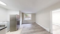Located at 1516 Bathurst Street in Toronto's vibrant Midtown neighbourhood, this compact one-bedroom, one-bathroom unit offers an efficient and well-organized layout across a single floor. Light-toned laminate wood flooring flows throughout the main living areas and bedroom, lending the space a clean, contemporary feel.

The kitchen is equipped with a stainless steel refrigerator, a white electric stove, and a countertop with an undermount sink. Tile flooring in the kitchen provides a practical transition from the main living area. A window in the kitchen/dining area allows natural light to filter in, offering a pleasant view of the surrounding brick exterior of the building.

The bedroom is a cozy, well-proportioned room featuring the same light laminate flooring, neutral warm-beige walls, and a window fitted with a wall-mounted air conditioning unit, ensuring year-round comfort. Baseboard heating is present throughout the unit, providing consistent warmth during colder months.

The bathroom is outfitted with a full-sized soaker bathtub and shower combination, surrounded by classic beige square wall tiles and chrome fixtures, complemented by a clean white vanity.

Overall, the unit presents a tidy, functional living space with a neutral palette and practical finishes, ideally suited for those seeking a straightforward home in central Toronto.