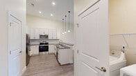 Located at 747 N DuPont Hwy in Dover, Delaware, this 2-bedroom, 2-bathroom residence offers a thoughtfully designed single-floor layout with modern finishes throughout. The open-concept kitchen and living area serves as the heart of the home, featuring a striking kitchen with white shaker cabinetry, dark countertops, a subway tile backsplash, stainless steel appliances including a refrigerator, range, microwave, and dishwasher, and pendant lighting above a breakfast bar peninsula. The spacious living room is bathed in natural light and opens directly to a private balcony through sliding glass doors, offering pleasant outdoor views. Both bedrooms are generously sized, featuring large windows, warm-toned walls, and durable hardwood-style flooring. The primary bedroom includes access to a dedicated closet. The two bathrooms are cleanly finished, with one showcasing a white vanity with dark countertop and a large mirror, while the other features accessible grab bars and a walk-in style shower. Light hardwood-style flooring flows consistently through the main living areas and kitchen, while darker flooring accents one of the bedrooms. Two hallways connect the space efficiently, and the overall ambiance is bright, clean, and move-in ready.