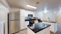 This single-floor residence in Little Rock, Arkansas, offers a practical and well-organized layout across two bedrooms and two bathrooms. The kitchen serves as a central feature, equipped with stainless steel appliances including a refrigerator, range, and over-the-range microwave. White shaker-style cabinetry provides ample storage, while dark granite countertops extend across a peninsula with a built-in sink, creating a natural boundary between the kitchen and the carpeted living area. Recessed panel lighting illuminates the kitchen effectively.

Both bedrooms feature neutral-toned carpet, ceiling fans with light fixtures, and windows that bring in natural light with views of the surrounding community. The primary bedroom includes two closets and a dedicated en-suite bathroom. The en-suite features a white vanity with dark granite countertops, wood-look flooring, and generous counter space. The second bathroom offers a full tub-shower combo with a curved curtain rod and a matching vanity setup. A dedicated laundry area and wood-look flooring in the main entry and wet areas complete this efficiently designed residence.