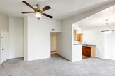 This single-floor residence offers a thoughtfully designed layout that balances comfort and functionality throughout. The main living area is generously sized, featuring warm neutral carpet, crisp white walls, and a ceiling fan with light fixture that adds both style and practicality. Natural light fills the space through a large window and sliding glass doors that open directly onto a private balcony, where mature trees provide a pleasant outdoor backdrop.

The kitchen is efficiently arranged with warm wood cabinetry, laminate countertops, and a full suite of appliances including a stainless steel refrigerator, electric range, and dishwasher. Herringbone-patterned wood-look flooring ties the kitchen and adjoining areas together with a classic, clean aesthetic.

The primary bedroom is a spacious retreat, complete with its own ceiling fan, plush carpet, and direct access to a walk-in closet. A second carpeted bedroom also features a ceiling fan and offers comfortable proportions. The primary bathroom is highlighted by a dual-sink vanity with warm wood cabinetry, stone-tone countertops, and wood-look flooring, creating a functional yet refined space.

A dedicated in-unit laundry area accommodates a full-size washer and dryer side by side, adding everyday convenience. The overall ambiance of the residence is bright, neutral, and move-in ready.