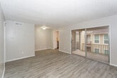 Located at 5208 11th St in Lubbock, Texas, this single-floor unit offers a clean, updated interior with a neutral color palette throughout. The open living area is finished with light wood-look laminate flooring that extends seamlessly across the space, complemented by textured ceilings and crisp white baseboards. A sliding glass door fills the living room with natural light and provides direct access to a private balcony, offering views of the surrounding neighborhood.

The kitchen is well-appointed with white cabinetry, light countertops, and stainless steel appliances including an electric range with overhead ventilation and a full-size refrigerator. The layout allows for efficient use of the space and connects conveniently to the main living area.

The bedroom features the same wood-look flooring and is naturally lit by a window with an exterior view. A ceiling fan adds comfort to the room. Throughout the unit, the design is consistent and cohesive, with soft gray-beige tones creating a calm, livable ambiance. The single-floor layout and functional floor plan make this a straightforward and practical space well-suited for everyday living in west Lubbock.