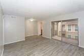 Located at 5208 11th St in Lubbock, Texas, this single-floor unit offers a clean, updated interior with a neutral color palette throughout. The open living area is finished with light wood-look laminate flooring that extends seamlessly across the space, complemented by textured ceilings and crisp white baseboards. A sliding glass door fills the living room with natural light and provides direct access to a private balcony, offering views of the surrounding neighborhood.

The kitchen is well-appointed with white cabinetry, light countertops, and stainless steel appliances including an electric range with overhead ventilation and a full-size refrigerator. The layout allows for efficient use of the space and connects conveniently to the main living area.

The bedroom features the same wood-look flooring and is naturally lit by a window with an exterior view. A ceiling fan adds comfort to the room. Throughout the unit, the design is consistent and cohesive, with soft gray-beige tones creating a calm, livable ambiance. The single-floor layout and functional floor plan make this a straightforward and practical space well-suited for everyday living in west Lubbock.