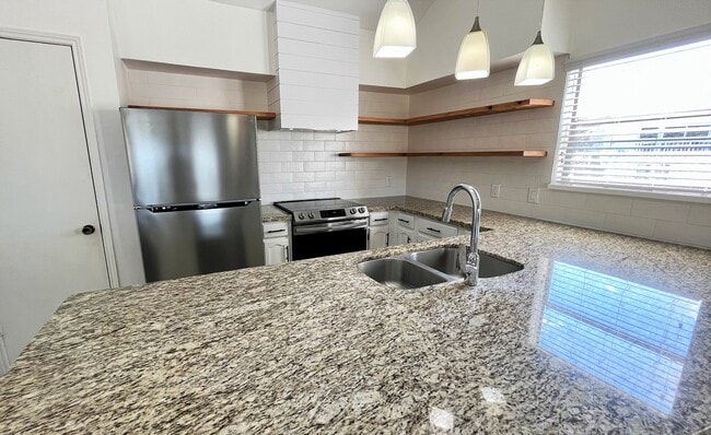 Kitchen / newly remodeled; features stainless steel appliances (fridge, stove, dishwasher, hood went - 103 April Point Dr N