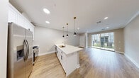 Located at 1774 E Second St in Scotch Plains, NJ, this well-appointed one-bedroom, two-bathroom unit offers a thoughtfully designed single-floor layout with modern finishes throughout. Light wood-tone flooring flows consistently across the living areas and bedroom, creating a warm, cohesive aesthetic.

The open-concept kitchen and living area serves as the heart of the unit. The kitchen features white shaker cabinetry, a spacious white quartz peninsula with an undermount sink, stainless steel appliances including a French door refrigerator and range, and stylish black-and-gold pendant lighting. Recessed lighting and crown molding add a polished touch to the space. Sliding glass doors in the living area open to a private balcony, bringing in natural light and outdoor views.

The generously sized primary bedroom includes a large window overlooking the exterior and continues the light wood flooring found throughout. The neutral warm-beige wall tones contribute to a calm, comfortable atmosphere.

Both bathrooms are finished with elegant marble-look tile on floors, walls, and tub surrounds. One bathroom features a white vanity with built-in open shelving, a large mirror, and chrome fixtures, reflecting a clean, contemporary design sensibility throughout the entire unit.