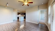 Located along US Highway 281 N in San Antonio, Texas, this two-bedroom, two-bathroom residence offers a well-designed single-level layout with a blend of comfort and functionality. The open-concept living and kitchen area serves as the heart of the home, featuring rich wood-look flooring, a ceiling fan with light fixture, and track lighting that adds a modern touch. The kitchen is appointed with dark espresso cabinetry, light granite-style countertops, a center island, pendant lighting, and black appliances, complemented by a pantry for additional storage. Two bedrooms provide comfortable retreats, each with plush carpeting, ceiling fans, and natural light from sizable windows. The primary bedroom includes access to dedicated closet space with built-in wire shelving. Both bathrooms feature dark wood vanities with granite-style countertops and wood-look flooring. The residence also includes a dedicated laundry area, a hallway connecting the living spaces, and four closets throughout, ensuring generous storage. Two private balconies extend the living space outdoors. Neutral warm-toned walls throughout create a cohesive and inviting atmosphere across every room.
