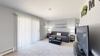 Located at 31 Harbor Dr in Claymont, Delaware, this 2-bedroom, 1-bathroom single-floor home offers a thoughtfully laid-out living space. The living room is bright and welcoming, featuring soft wall-to-wall carpeting, neutral gray walls, and a large sliding glass door dressed with vertical blinds that fills the room with natural light. A dedicated dining area provides an intimate setting for meals, while the galley-style kitchen impresses with white shaker cabinetry, granite-look countertops, stainless steel appliances, and wood-look plank flooring — a clean, modern aesthetic throughout. The primary bedroom offers a comfortable retreat with carpeted flooring, a natural light-filled window, and two closets for ample storage. The second bedroom is similarly carpeted and well-proportioned. The shared bathroom features a wide vanity with white cabinetry, granite-style countertops, a large mirror, and wood-look flooring, lending a fresh and updated feel. A connecting hallway ties all areas together efficiently. The overall ambiance is clean, neutral, and move-in ready, with consistent modern finishes throughout the home.
