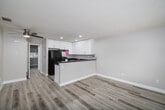 Located at 1825 E Valley Pkwy in Escondido, CA, this one-bedroom, one-bathroom unit offers a thoughtfully designed single-level layout with modern finishes throughout. Light wood-look flooring runs continuously across the space, complementing the neutral gray-toned walls and clean white trim to create a bright, cohesive aesthetic.

The open-concept kitchen is a standout feature, equipped with white shaker-style cabinetry extending to the ceiling for ample storage, dark granite countertops, a double stainless steel sink, and stainless steel appliances including a refrigerator and range. A peninsula counter opens seamlessly to the combined dining and living area, enhancing the sense of openness and making the space ideal for everyday living and entertaining.

The bedroom is a comfortable, well-proportioned room featuring a large window with blinds that allows natural light and outdoor views of the surrounding neighborhood. A sliding-door closet provides practical built-in storage. An additional closet elsewhere in the unit adds further storage flexibility.

The bathroom is clean and functional, featuring a full tub and shower combination with a tiled surround. Throughout the unit, recessed lighting and a well-maintained interior reflect a move-in-ready condition with updated finishes that suit a modern lifestyle.