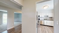 Located at 6454 Freedom Dr in Glen Burnie, Maryland, this two-floor home offers a well-organized layout with a clean, modern aesthetic throughout. The kitchen is a standout feature, outfitted with crisp white shaker-style cabinetry, granite countertops, a subway tile backsplash, and a full suite of stainless steel appliances including a range, microwave, and dishwasher. Light wood-style flooring runs through the kitchen and main-level common areas, lending warmth and cohesion to the space. The living areas are open and connected, with neutral grey walls and plush carpeting creating a comfortable, inviting atmosphere. A staircase connects the two floors, and vertical blinds on a sliding door allow for natural light and outdoor access. The bedrooms are generously sized, carpeted for comfort, and benefit from multiple windows that bring in natural light and views of the surrounding greenery. The bathrooms are tastefully appointed with granite-topped vanities and wood-style flooring; the full bath features a tub-shower combination, while a separate half bath includes a bright window for ventilation. Throughout the home, a consistent palette of soft neutrals and quality finishes creates a cohesive, move-in-ready environment.