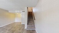 Located at 2420 Central Park Dr in Melbourne, FL, this two-story, 2-bedroom, 2-bathroom home offers a well-organized layout spread across two floors. The main level features a bright living room with wood-look plank flooring, a textured ceiling, and a carpeted staircase leading to the upper level. The kitchen is well-appointed with white shaker-style cabinetry, granite countertops, stainless steel appliances including a refrigerator, range, microwave, and dishwasher, and light tile flooring. A hallway with a louvered closet door connects the kitchen to the main-floor bathroom, which includes a granite vanity with an undermount sink. The upper level hosts both bedrooms, each featuring plush carpet flooring and neutral wall tones. The primary bedroom benefits from a large window that invites generous natural light and outdoor views, and is equipped with a ceiling fan. The second bedroom is comfortably sized with easy access to the second full bathroom, which offers a tub-shower combination with white tile surround. Throughout the home, a consistent neutral color palette and clean finishes create a bright, functional living environment suitable for a variety of lifestyles.