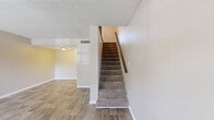 Located at 2420 Central Park Dr in Melbourne, FL, this two-story, 2-bedroom, 2-bathroom home offers a well-organized layout spread across two floors. The main level features a bright living room with wood-look plank flooring, a textured ceiling, and a carpeted staircase leading to the upper level. The kitchen is well-appointed with white shaker-style cabinetry, granite countertops, stainless steel appliances including a refrigerator, range, microwave, and dishwasher, and light tile flooring. A hallway with a louvered closet door connects the kitchen to the main-floor bathroom, which includes a granite vanity with an undermount sink. The upper level hosts both bedrooms, each featuring plush carpet flooring and neutral wall tones. The primary bedroom benefits from a large window that invites generous natural light and outdoor views, and is equipped with a ceiling fan. The second bedroom is comfortably sized with easy access to the second full bathroom, which offers a tub-shower combination with white tile surround. Throughout the home, a consistent neutral color palette and clean finishes create a bright, functional living environment suitable for a variety of lifestyles.
