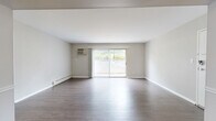 Located at 10 Meadow Dr in Milford, Ohio, this single-floor residence offers a practical and comfortable layout comprising one bedroom, two bathrooms, a combined kitchen and living room, and a dedicated dining area. The living room is a bright, open space finished with durable hardwood-style flooring and neutral-toned walls. A full-width sliding glass door floods the room with natural light and provides direct access to an outdoor area, while vertical blinds offer privacy and light control. A wall-mounted AC unit and baseboard heating ensure year-round comfort. The adjoining dining area features a ceiling fan and connects seamlessly to the kitchen, which is equipped with warm oak cabinetry, granite-style countertops, and a classic subway tile backsplash. The spacious primary bedroom is carpeted for comfort, includes a large closet with bifold doors, a window with outdoor views, and baseboard heating. A second bathroom features an oak vanity with a white countertop and generous closet storage nearby. The main bathroom includes a full tub-shower combination with white tile surround and hardwood-style flooring. Throughout, the space maintains a clean, functional aesthetic suited for comfortable everyday living.