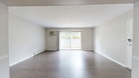 Located at 10 Meadow Dr in Milford, Ohio, this single-floor residence offers a practical and comfortable layout comprising one bedroom, two bathrooms, a combined kitchen and living room, and a dedicated dining area. The living room is a bright, open space finished with durable hardwood-style flooring and neutral-toned walls. A full-width sliding glass door floods the room with natural light and provides direct access to an outdoor area, while vertical blinds offer privacy and light control. A wall-mounted AC unit and baseboard heating ensure year-round comfort. The adjoining dining area features a ceiling fan and connects seamlessly to the kitchen, which is equipped with warm oak cabinetry, granite-style countertops, and a classic subway tile backsplash. The spacious primary bedroom is carpeted for comfort, includes a large closet with bifold doors, a window with outdoor views, and baseboard heating. A second bathroom features an oak vanity with a white countertop and generous closet storage nearby. The main bathroom includes a full tub-shower combination with white tile surround and hardwood-style flooring. Throughout, the space maintains a clean, functional aesthetic suited for comfortable everyday living.