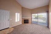 Located at 2530 Bear Valley Parkway in Escondido, CA, this 2-bedroom, 2-bathroom residence offers a well-designed single-level layout with a range of functional and aesthetic features throughout.

The living room is a standout space, showcasing soaring vaulted ceilings that lend an open, airy feel. A tile-surround fireplace serves as a focal point, while a sliding glass door opens directly onto a private balcony, filling the room with natural light and providing outdoor access.

The kitchen and dining area are open and practical, featuring light wood cabinetry, dark granite countertops with a breakfast bar overhang, stainless steel appliances including a refrigerator and microwave, and tile flooring. This space flows naturally for both cooking and casual dining.

Both bedrooms are carpeted and well-lit by natural light through sizable windows. The primary bedroom is generously sized and includes a spacious walk-in closet with built-in shelving and hanging rods.

The two bathrooms mirror each other in finish quality, each appointed with dark granite vanity countertops, light wood cabinetry, tile flooring, and full tile tub/shower surrounds in a warm stone tone.

Additional highlights include a dedicated laundry area, a utility room, a hallway connecting the main spaces, and warm neutral tones carried throughout the entire residence.