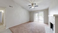 This single-story residence offers a well-organized layout with a variety of thoughtful finishes throughout. The main living area is notably spacious, characterized by vaulted ceilings that enhance the sense of openness. A ceiling fan with a light fixture is centrally mounted, providing both airflow and illumination. Soft, neutral-toned carpet covers the floor, and a sliding glass door fitted with vertical blinds fills the room with natural light while providing access to an outdoor area with views of surrounding greenery.

A transition area connects the living space to additional rooms, featuring light wood-look flooring and elevated ceilings that continue the airy feel of the home. The kitchen is equipped with stainless steel appliances, including an electric range and an over-the-range microwave, complemented by white cabinetry, granite-style countertops, and a classic subway tile backsplash.

The bedrooms are carpeted and offer generous closet space, including sliding-door closets with built-in shelving and hanging rods. The bathrooms are clean and functional, featuring tiled shower-tub combinations, white fixtures, wood-look tile flooring, and vanities with granite-style countertops. Textured ceilings are present throughout the residence.