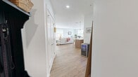 Located at 110 Peter Kristof Way in Medfield, MA, this thoughtfully designed single-floor residence offers two bedrooms and two bathrooms across a generous, open layout. Light-toned hardwood-style flooring flows throughout the living spaces, complementing the bright, neutral color palette found in every room.

The kitchen is a standout feature, showcasing two-tone cabinetry with warm wood lower cabinets and crisp white uppers, a subway tile backsplash, stainless steel appliances including a gas range with a stainless wall-mounted range hood, and a large island with seating for multiple guests, illuminated by elegant brass pendant lights.

The adjoining dining room is bathed in natural light from multiple windows with views of surrounding greenery, and features wall sconces that add a warm ambiance. The living room maintains the same airy, bright character with large windows and clean, open sightlines.

The spacious primary bedroom offers ample room and natural light, while the second bedroom provides a comfortable, well-proportioned retreat. Both bathrooms are finished with large-format tile flooring and light wood vanity cabinetry, with one bathroom featuring a tub-shower combination with marble-style tile surround. The overall ambiance is clean, modern, and welcoming throughout.
