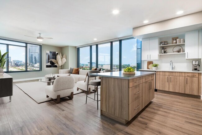 Disfrute de una cocina moderna con gabinetes de 42” de cierre suave con iluminación debajo de los gabinetes, encimeras de cuarzo y estantes abiertos para mayor funcionalidad y estilo. - Modera McGavock