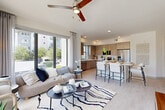 Located at 425 Centerpointe Circle in Altamonte Springs, FL, this well-appointed 2-bedroom, 2-bathroom residence offers a thoughtfully designed single-floor layout with modern finishes throughout. The open-concept living, dining, and kitchen area serves as the heart of the home, anchored by floor-to-ceiling sliding glass doors that flood the space with natural light and offer views of the surrounding greenery. A ceiling fan, light wood-style flooring, and recessed lighting contribute to the bright, airy ambiance. The kitchen is outfitted with warm wood-tone cabinetry, white quartz countertops, a subway tile backsplash, stainless steel appliances, and a central island with bar seating — ideal for both cooking and casual dining. A light-filled hallway with clean white walls leads to the private quarters. Both bedrooms feature large windows, ceiling fans, and a calm, neutral palette. The primary bedroom includes an en-suite bathroom with marble-style tile flooring, a wood-tone vanity with quartz countertops, a large mirror, and a glass-enclosed shower. Additional features include four closets, a dedicated laundry area, and a utility room, ensuring practical storage and convenience throughout.