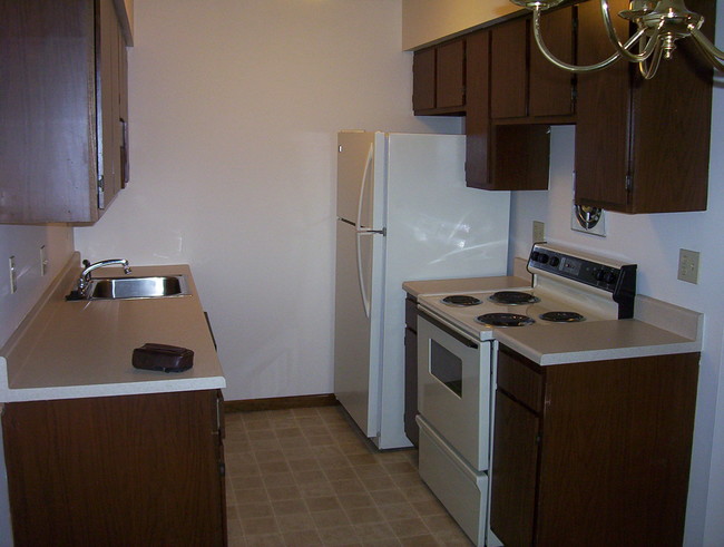 Nuestras cocinas están totalmente equipadas con un refrigerador, una cocina, un triturador de basura y un lavaplatos. - Old Orchard By The Bay Apartments