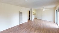 Located at 801 S Lyon St in Santa Ana, California, this single-floor unit offers a clean, functional layout with consistent wood-look flooring throughout. The open living area is spacious and bright, featuring a ceiling fan, a wall-mounted heating unit, and direct sightlines to the kitchen — creating a practical, connected flow between the two spaces. Textured ceilings are present throughout the unit, adding a classic residential character.

The kitchen is efficiently designed with white cabinetry, granite-style laminate countertops, a double stainless steel sink, a dishwasher, and ample upper cabinet storage. A built-in pantry or storage closet is conveniently positioned adjacent to the kitchen.

The bedroom is well-proportioned, featuring a sliding closet, a window with vertical blinds that allows natural light, and a wall-mounted air conditioning unit for individual climate control. The bathroom is neatly appointed with a granite-style vanity, a full tub and shower combo, and wood-look flooring that carries through from the rest of the unit.

Overall, the space presents a neutral, move-in-ready palette with warm flooring tones, white trim, and an open, uncluttered layout that offers both comfort and practicality.