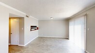 Located at 1968 Clinton Rd in Macon, Georgia, this two-story home offers three bedrooms, two bathrooms, and a thoughtfully organized layout spread evenly across two floors. The main level features a combined living and dining area with light wood-look flooring, crown molding, a textured ceiling, and a sliding glass door that fills the space with natural light and provides outdoor access. A pass-through window connects the living area to the kitchen, which is equipped with dark laminate countertops, white cabinetry, a stainless steel refrigerator, a dishwasher, and a window above the sink. Both bathrooms include a vanity with a wood-tone cabinet and mirror, with one bathroom featuring a full tub-shower combo and tile flooring. The bedrooms are carpeted and include built-in closets with hanging rods for convenient storage — with five closets total throughout the home offering ample organization space. A dedicated laundry area and multiple hallways contribute to the home's practical flow. The upper level mirrors the lower in footprint, maintaining a consistent, efficient layout. Crown molding and neutral tones throughout lend a clean, cohesive look to the interior.
