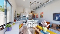 Located at 1481 Blazing Star Blvd in Eau Claire, WI, this thoughtfully designed one-bedroom, one-bathroom unit offers an efficient and stylish layout across a single floor. The open-concept living and kitchen area is anchored by soaring ceilings with exposed ductwork, giving the space an industrial-chic character. Warm wood-look flooring runs throughout, complemented by abundant natural light streaming through large black-framed windows.

The kitchen is a standout, featuring crisp white cabinetry, a grey tile backsplash, stainless steel appliances including a full-size refrigerator, range, microwave, and dishwasher, along with a central island with seating — ideal for both cooking and entertaining. Pendant lighting with woven rattan shades adds warmth to the space.

The bedroom is generously proportioned with tall ceilings, large windows offering outdoor views, and direct access to a walk-in closet outfitted with built-in shelving and double hanging rods. The bathroom includes a walk-in shower, a floating vanity with a backlit mirror, and wood-look tile flooring. A dedicated laundry room with a full-size washer and dryer completes this well-appointed unit.