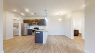 This thoughtfully designed 2-bedroom, 2-bathroom residence offers a comfortable and functional single-floor layout with modern finishes throughout. The open-concept kitchen and living area serves as the heart of the home, featuring dark espresso cabinetry, a classic white subway tile backsplash, granite countertops, a full suite of stainless steel appliances — including a refrigerator, range, microwave, and dishwasher — and a peninsula with pendant lighting that anchors the space. Light wood-tone luxury vinyl flooring flows seamlessly throughout, enhancing the bright and airy atmosphere created by recessed lighting and ample natural light. The spacious primary bedroom includes a walk-in closet and a sliding glass door that opens to a private balcony with open scenic views. The second bedroom is generously sized with its own closet and a large window. Both bathrooms are finished with granite-topped vanities matching the dark cabinetry found in the kitchen, and the second bathroom includes a full tub-shower combination with white subway tile surround. A dedicated laundry room with an in-unit washer and dryer and built-in shelving adds everyday convenience. The overall ambiance is clean, contemporary, and move-in ready.