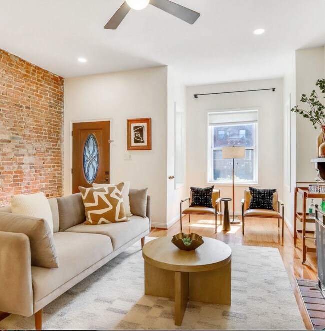Living room with exposed brick and decorative fireplace - 1630 6th St NW