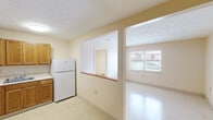 Located at 3716 Trent Cir, Unit 710, in Lexington, KY, this one-bedroom, one-bathroom unit offers a practical and efficient single-floor layout. The open-concept design connects the kitchen and living room, creating a cohesive and functional living space. A half-wall with a wood-topped bar divider separates the kitchen from the living area while maintaining an open feel throughout.

The kitchen is well-equipped with warm oak cabinetry spanning both upper and lower sections, a white refrigerator, an electric range, and a single-basin sink with a window pass-through that allows natural light to flow between rooms. Light tile flooring runs throughout the unit, providing a clean, consistent look.

The living area is open and bright, benefiting from a window that offers an exterior view, and features a baseboard heating system. Two closets provide ample storage, including one open closet visible from the main living space. The bedroom is comfortably sized with its own window, baseboard heater, and easy access to the rest of the unit.

The bathroom features tile flooring in an earthy stone pattern, a toilet, and a sink, with a door that connects to an adjacent closet or utility area. A textured ceiling is present throughout much of the unit, adding a classic residential character to the overall design.