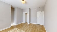 Located at 260 S Mariposa Ave in the Koreatown neighborhood of Los Angeles, this single-floor unit offers a well-organized and efficient layout comprising a living room, kitchen, and bathroom. Throughout the space, light wood laminate flooring provides a warm, cohesive foundation that reflects natural light streaming in through sizable windows fitted with blinds.

The living area is bright and open, featuring neutral gray walls, white trim, and a globe ceiling light fixture. A wall-mounted heater unit provides in-unit climate control, and a built-in closet with a rod offers practical storage. The entry door opens directly into this versatile space.

The galley-style kitchen is thoughtfully appointed with white cabinetry, a warm wood-toned countertop, and a stainless steel sink. A teal mosaic tile backsplash adds a pop of color, while stainless steel appliances — including a gas range and over-the-range microwave — round out the functional cooking space. A refrigerator is also included.

The bathroom features large-format neutral tile on the walls surrounding a full soaking tub with an overhead shower. A window above the tub brings in natural light, and a pedestal sink and mirrored medicine cabinet complete the space.

Overall, the unit presents a clean, move-in-ready aesthetic with consistent finishes throughout, making it a practical and comfortable space in a central Los Angeles location.