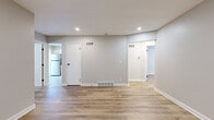 Located at 9506 W 87th St in Overland Park, Kansas, this single-story, 3-bedroom, 1-bathroom home offers a clean, modern aesthetic with thoughtful updates throughout. Light wood-look flooring flows seamlessly across every room, complemented by neutral gray walls and crisp white trim, creating a bright and cohesive feel.

The open living area features recessed lighting and multiple vents for efficient climate control, with clear sightlines connecting to the rest of the home via a central hallway. A sliding glass door with vertical blinds in one of the rooms invites natural light and provides outdoor views. The spacious primary bedroom includes a dedicated closet with built-in rod, a window with blinds, and ample room to furnish comfortably.

The kitchen is well-appointed with white shaker-style cabinetry, gray quartz-style countertops, a stainless steel refrigerator, electric range, and dishwasher — all finished with sleek black hardware. The bathroom continues the modern theme with white cabinetry, a gray countertop vanity, black drawer pulls, and a large mirror. Two closets provide practical storage, and a connecting hallway ties all spaces together efficiently. The home presents a freshly updated, move-in ready interior throughout.