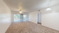 Located at 2075 N Highland Ave in Clearwater, FL, this single-floor residence offers a practical and comfortable layout with two bedrooms, two bathrooms, and a thoughtfully arranged floor plan. The combined living and dining area serves as the heart of the home, featuring plush carpeting, a textured ceiling, a ceiling fan, and wide sliding glass doors that invite abundant natural light and provide direct access to an outdoor latticed patio area. A pendant light fixture distinguishes the dining portion of this open shared space. The kitchen is equipped with white cabinetry, a double-basin sink, laminate countertops, and hardwood-style flooring, with a large window offering pleasant outdoor views. The spacious primary bedroom benefits from multiple windows on two walls, flooding the room with natural light and views of surrounding greenery. The second bedroom also features carpet, a ceiling fan, and windows that bring in natural light. Four closets throughout the home provide generous storage. The two bathrooms are clean and functional — one featuring a walk-in shower and the other a full soaking tub — both with hardwood-style flooring and crisp white finishes. A hallway connects the bedrooms and bathrooms, completing this well-organized and move-in ready layout.