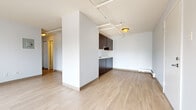 This single-floor residence offers a clean, functional layout designed for comfortable everyday living. The open-concept living and dining area is finished with light wood-look flooring that extends throughout the main spaces, creating a bright and cohesive feel. A textured ceiling and track lighting add a practical, modern touch, while baseboard heaters ensure efficient warmth throughout. A structural half-wall neatly separates the living area from the kitchen zone without closing off the space.

The galley-style kitchen is well-appointed with dark espresso cabinetry on both sides, light countertops, a stainless steel sink, and white appliances including a refrigerator, electric range, and dishwasher. Generous upper and lower cabinet storage makes the kitchen highly functional.

The bedrooms are carpeted for comfort and feature neutral walls, wall sconce lighting, and sliding closet doors with built-in hanging rails providing practical storage. One bedroom benefits from a window that allows natural light to fill the room.

The bathroom features a clean, all-white surround bath and shower unit. Throughout the residence, the consistent use of neutral tones, light flooring, and white walls contributes to an open, airy ambiance that is easy to personalize.
