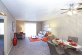 This single-floor unit offers a well-organized layout that connects key living spaces efficiently. The living room is carpeted and generously sized, featuring a textured ceiling, neutral tan walls, and a large sliding glass door that allows natural light to fill the space. The open feel is complemented by a connected area that leads to the kitchen and bedroom corridor.

The galley-style kitchen is outfitted with white cabinetry on both sides, black appliances including a range and dishwasher, a stainless steel sink, tile backsplash, and wood-look flooring, providing a clean and functional workspace.

The bedroom accommodates a large bed comfortably and includes a window with exterior views, a textured ceiling, and neutral carpeting. A dedicated walk-in closet off the bedroom features built-in shelving and a hanging rod for organized storage. An additional standard closet is also accessible from the bedroom area.

The bathroom includes a shower-tub combination, a vanity with countertop storage, a toilet, and wood-look flooring, maintaining a clean and practical design.

Throughout, the unit features consistent neutral tones, textured ceilings, and carpeted living and sleeping areas, creating a cohesive and functional living environment.
