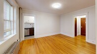 Located at 11 Shepley St in Portland, Maine, this one-bedroom, one-bathroom unit offers a well-organized layout across a single floor. Warm hardwood floors run throughout the main living areas and bedroom, complemented by crisp white walls and classic crown molding that lend a timeless character to the space.

The living room is bright and open, featuring a flush ceiling light and a cast-iron radiator beneath a double-paned window that brings in natural light. Crown molding continues throughout, reinforcing the traditional architectural details. An entrance provides a natural transition into the living area, while doorways connect seamlessly to the other rooms.

The bedroom is a cozy and functional space, outfitted with a ceiling fan, hardwood floors, and crown molding consistent with the rest of the unit. A rich wood-toned door adds warmth and contrast to the neutral walls.

The kitchen is efficiently designed with dark lower cabinetry, white upper cabinets, a subway tile backsplash, and stainless steel appliances including a refrigerator, electric range, and dishwasher. A stainless steel sink and gray countertops complete the functional workspace.

The bathroom is clean and modern, featuring large-format tile flooring, a walk-in shower with white subway tile walls, matte black fixtures, and a white vanity. The overall aesthetic is minimal and fresh throughout.