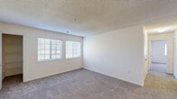This single-floor residence offers a well-organized layout with 2 bedrooms, 2 bathrooms, a kitchen, and a closet. The galley-style kitchen features warm oak cabinetry, ample counter space, a double sink, and white appliances including a coil-top range and refrigerator, all set over light hardwood-style flooring. An adjacent living area extends from the kitchen, complete with a ceiling fan and a seamless flow between spaces. Both bedrooms are carpeted and finished with neutral white walls and textured ceilings, creating a clean, bright atmosphere. The spacious primary bedroom includes dual closets with built-in hanging rods, offering generous storage. The second bedroom also features a closet and a window that brings in natural light. Both bathrooms are outfitted with full-sized tub and shower combinations, chrome fixtures, and clean white surrounds. Throughout the residence, soft carpet in the living and sleeping areas contrasts with the easy-care hard-surface flooring in the kitchen. Windows in the bedrooms allow natural light to fill the rooms, contributing to an open and airy feel. The straightforward, functional design of this single-story home makes it a practical and comfortable living space.